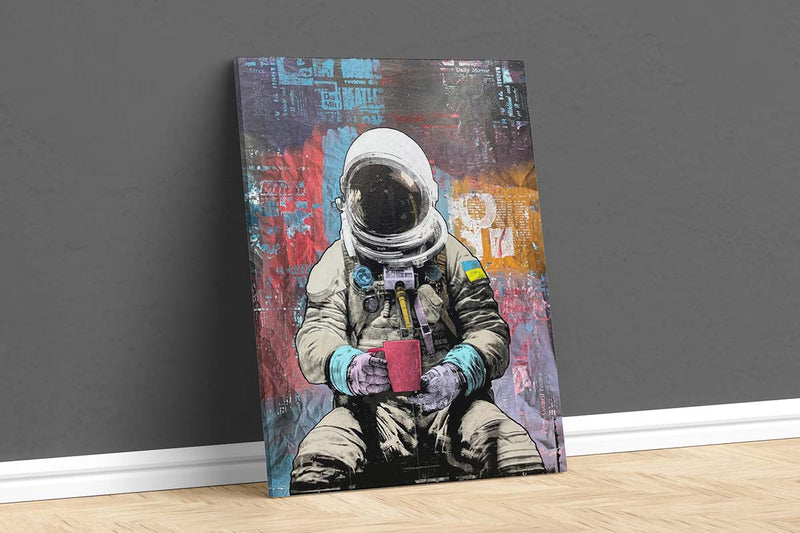 A canvas art print of a person in a spacesuit sitting down holding a mug